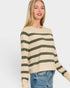 Woman wearing a beige and green striped sweater on a white background