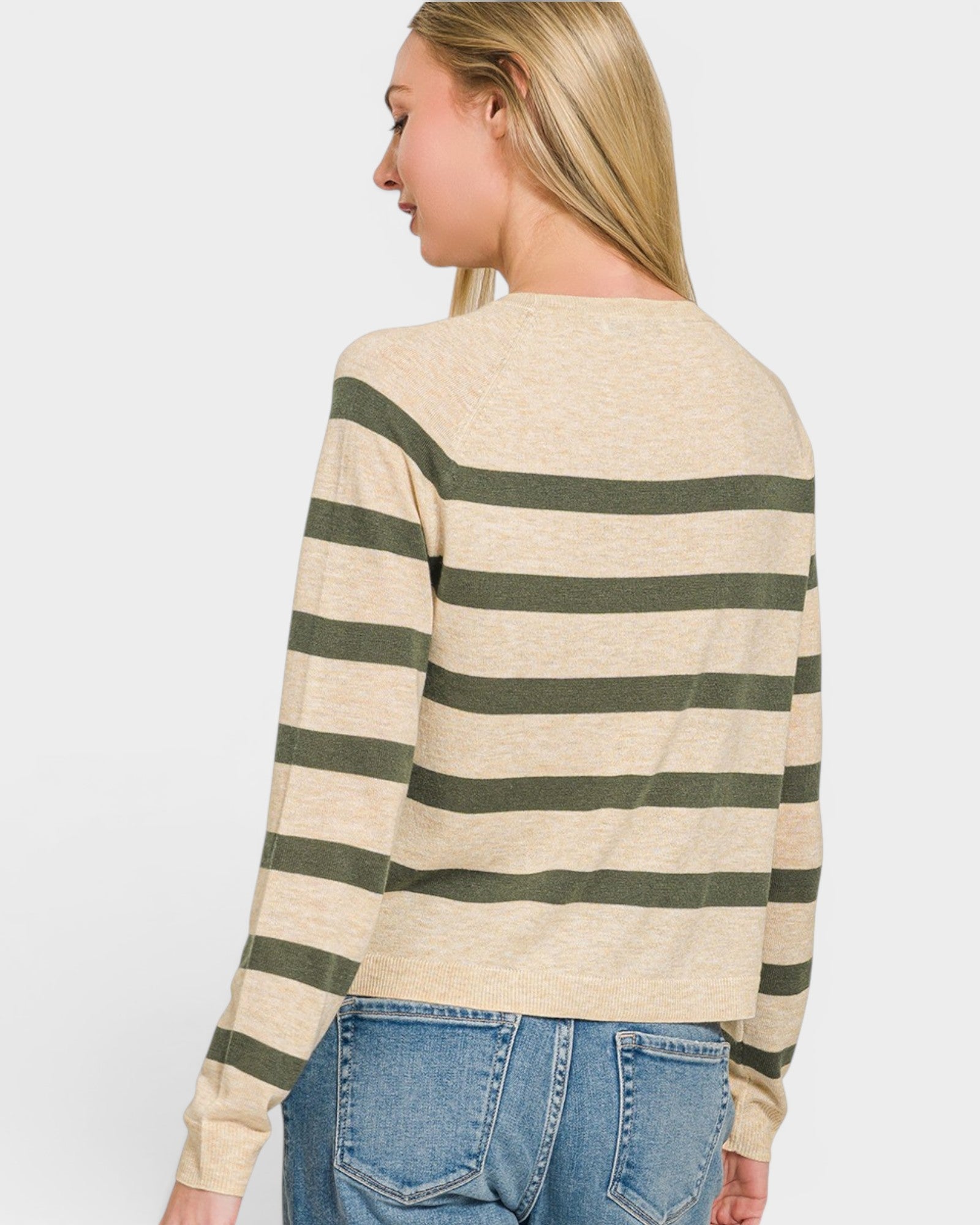 Woman wearing a beige and green striped sweater on a white background