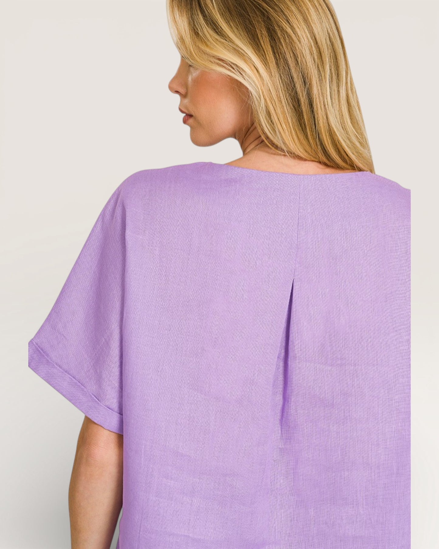 Woman wearing a purple top against a plain background