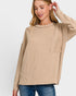 Woman wearing a beige ribbed sweater with a pocket on a white background