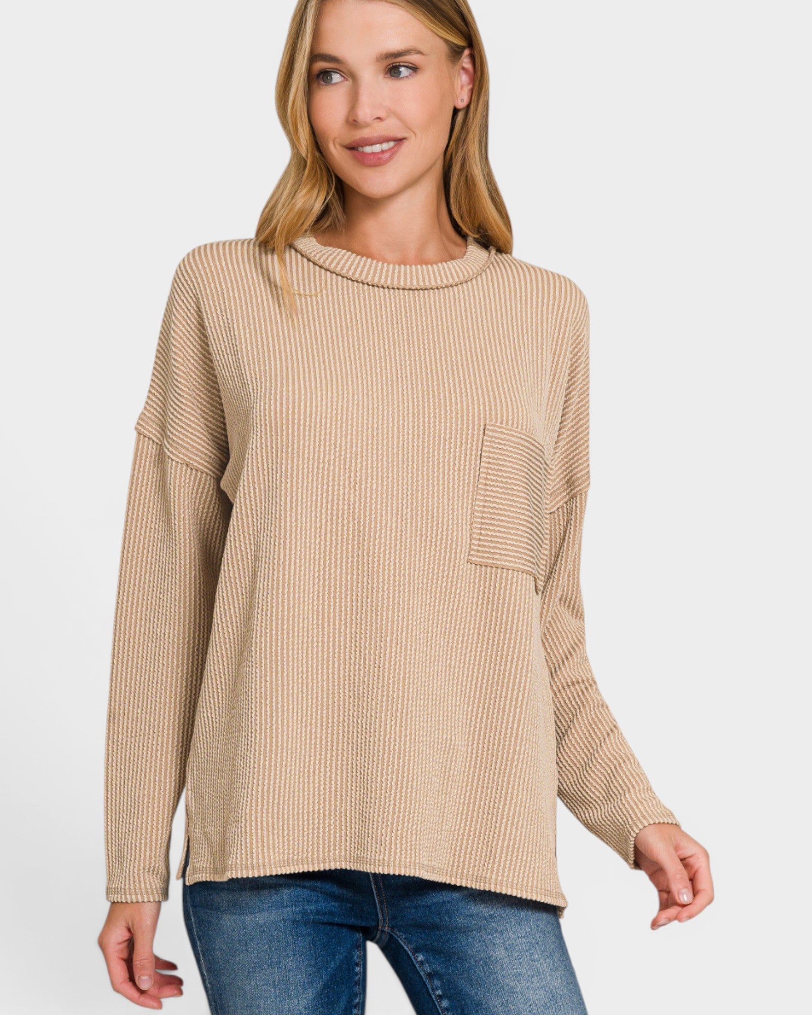 Woman wearing a beige ribbed sweater with a pocket on a white background