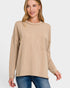 Woman wearing a beige ribbed sweater with a pocket on a white background