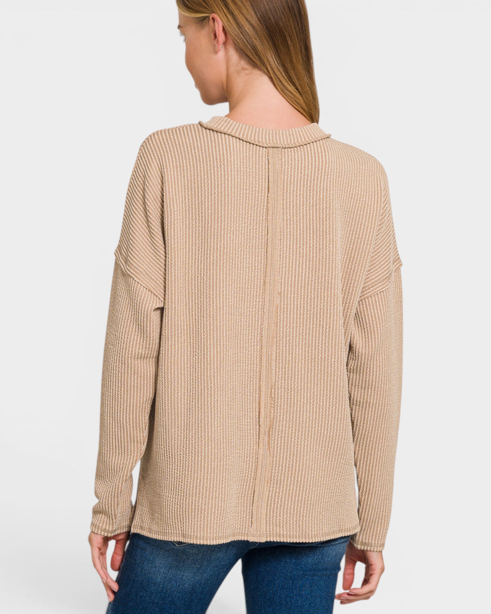 Woman wearing a beige ribbed sweater on a white background