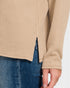 Beige knitted sweater and blue jeans on a neutral background