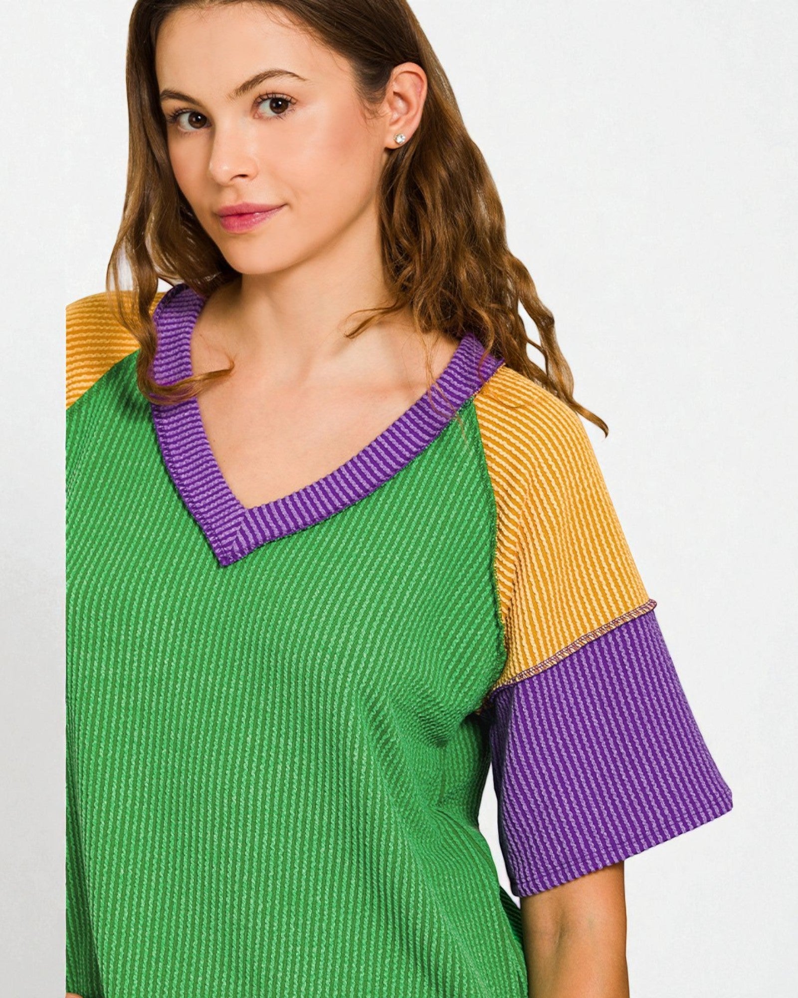 Woman wearing a green, yellow, and purple dress on a white background