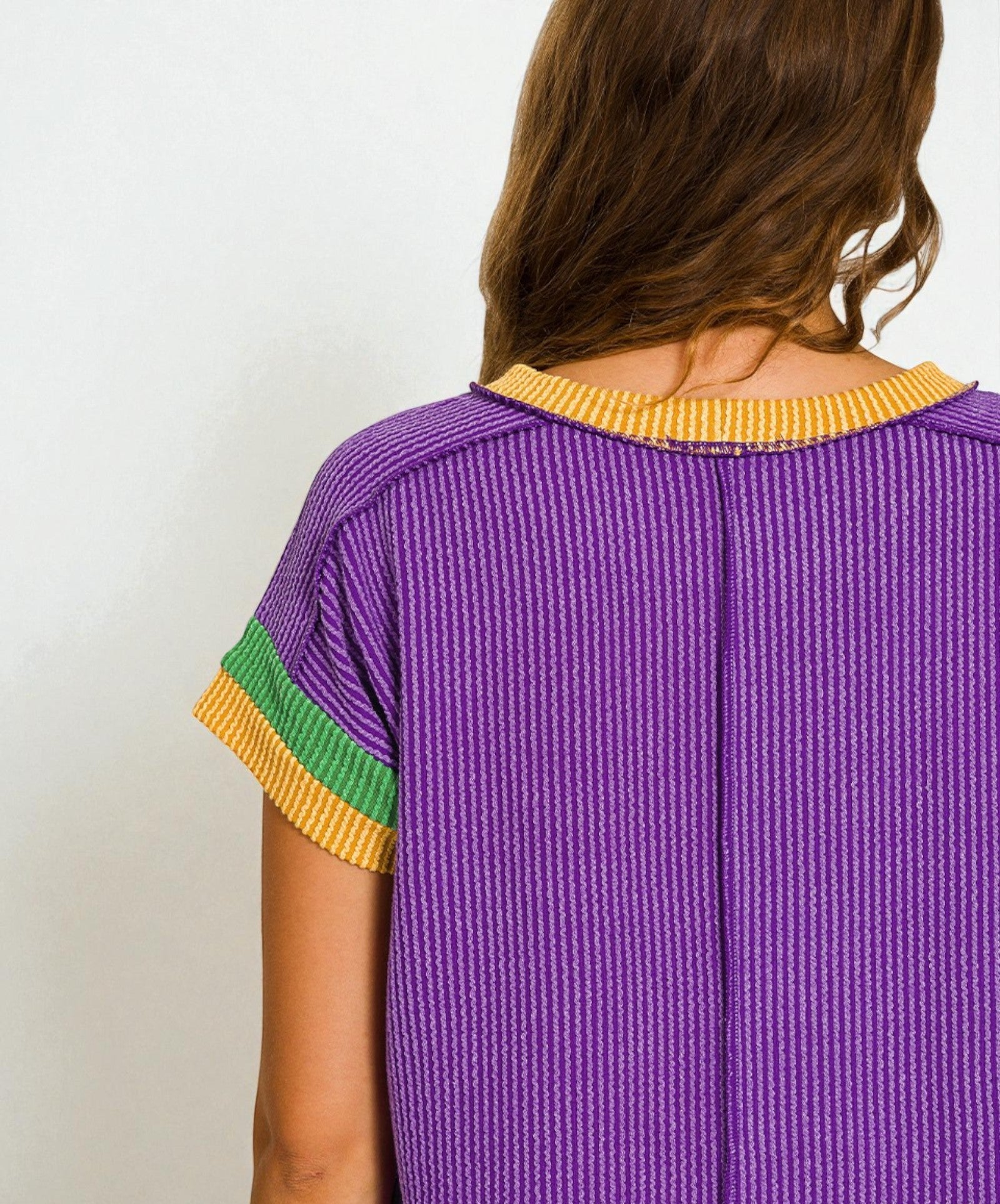 Purple textured dress with yellow and green accents on a plain background