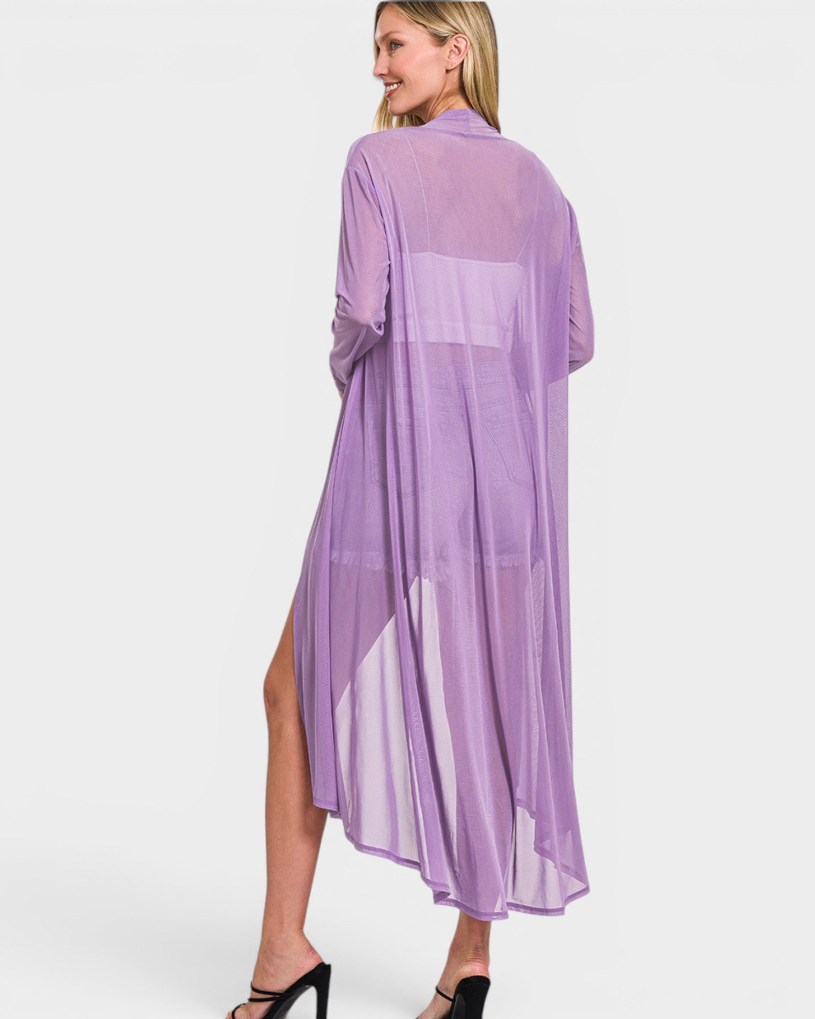 Woman wearing a purple sheer cardigan with a white background