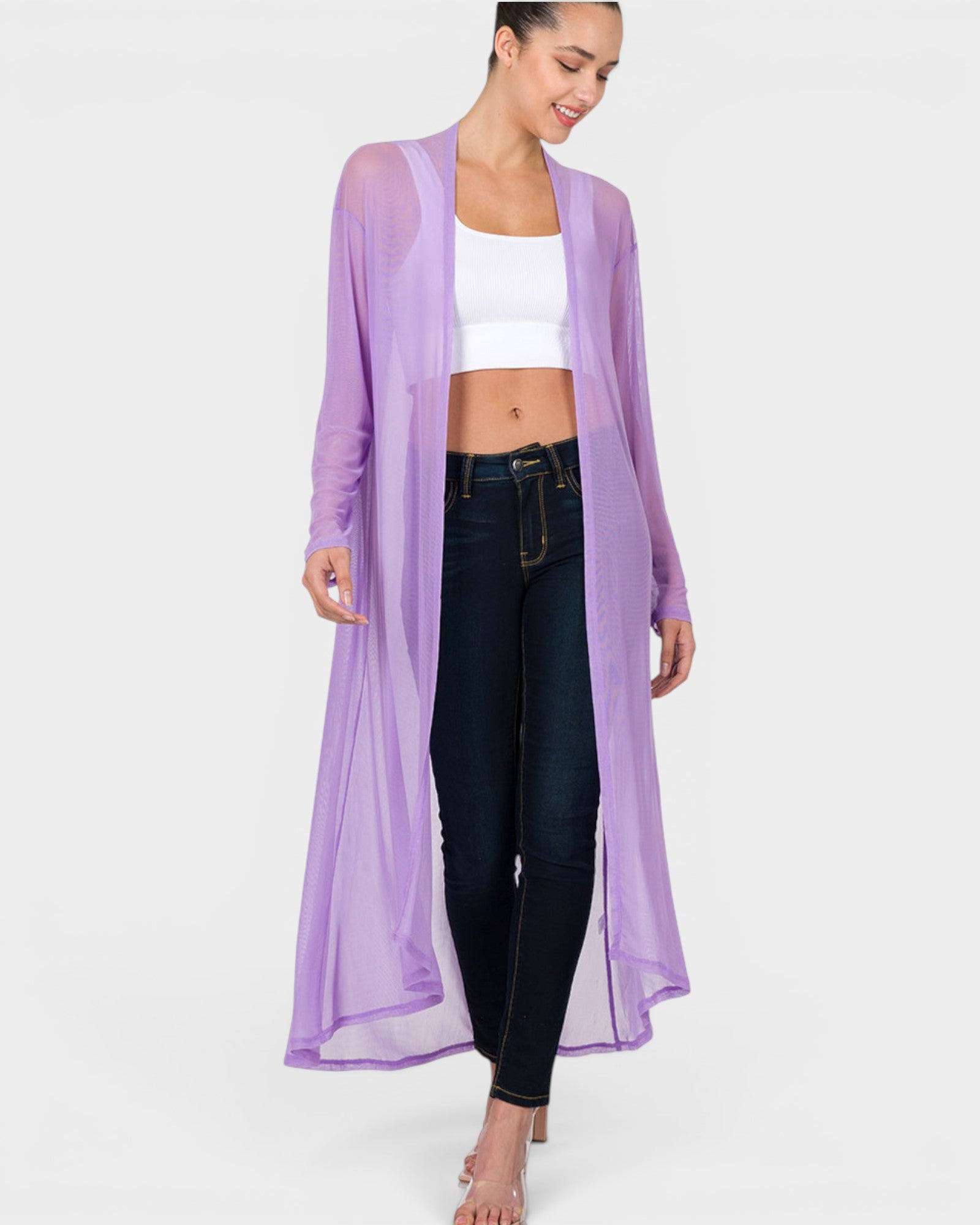 Woman wearing a long purple cardigan over a white top and black pants on a white background