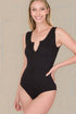 Woman wearing a black bodysuit against a neutral background
