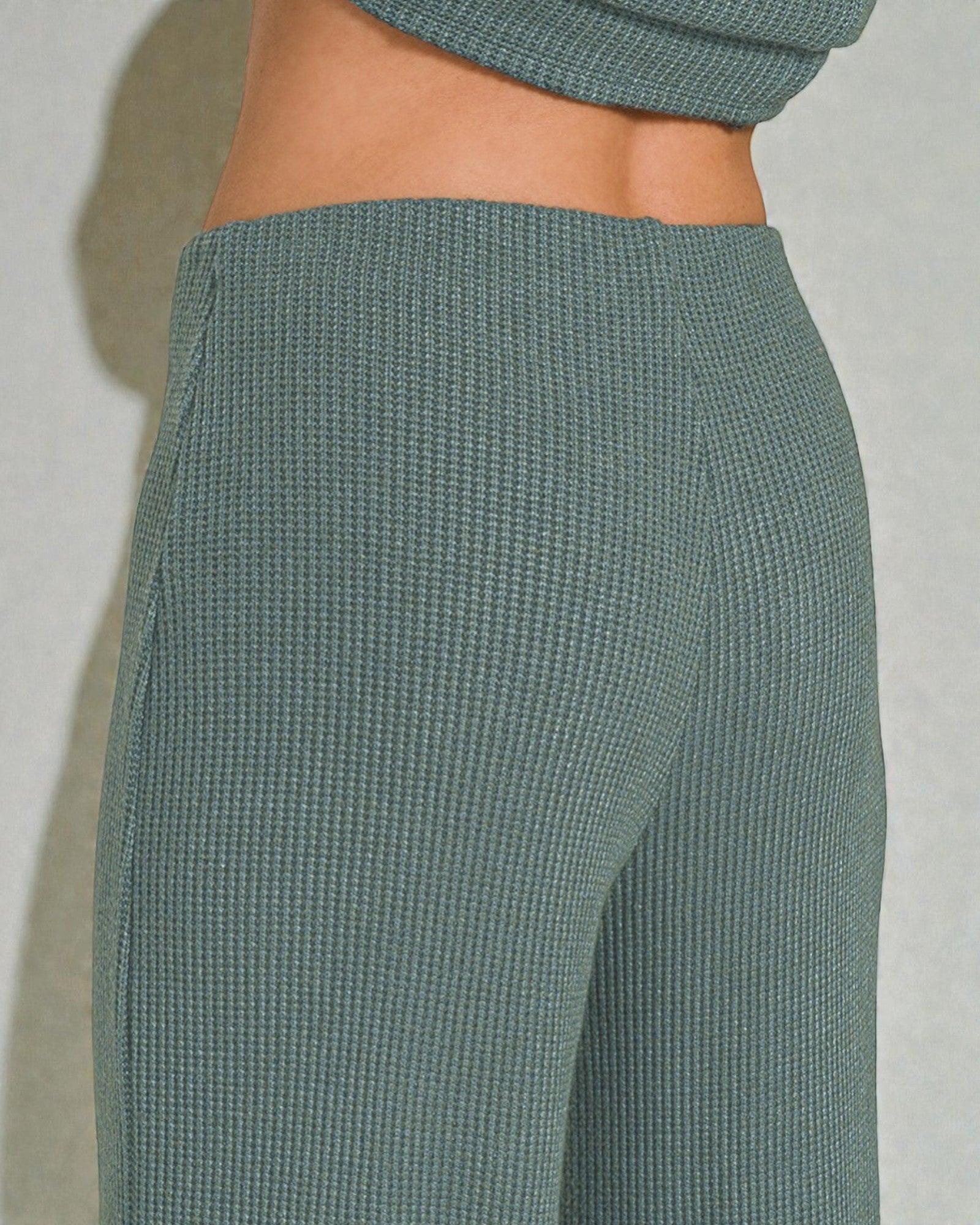 Teal ribbed pants on a plain background