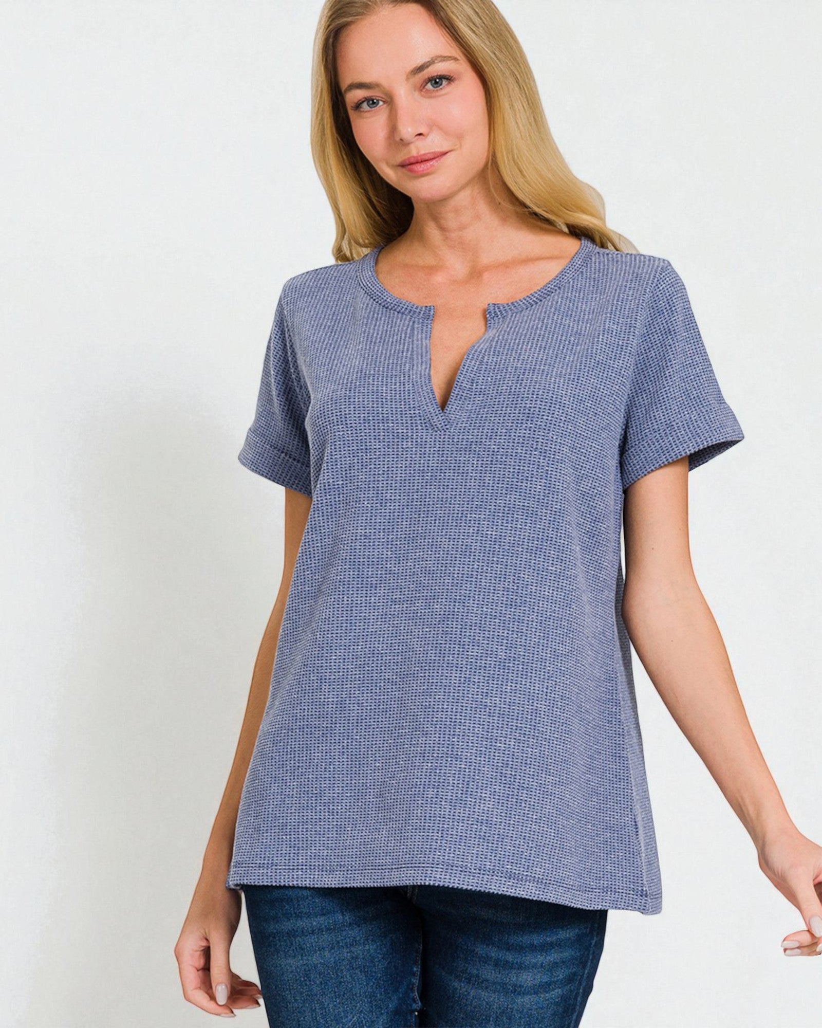 Woman wearing a blue textured top on a white background