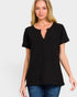 Woman wearing a black t-shirt with a deep neckline on a plain background