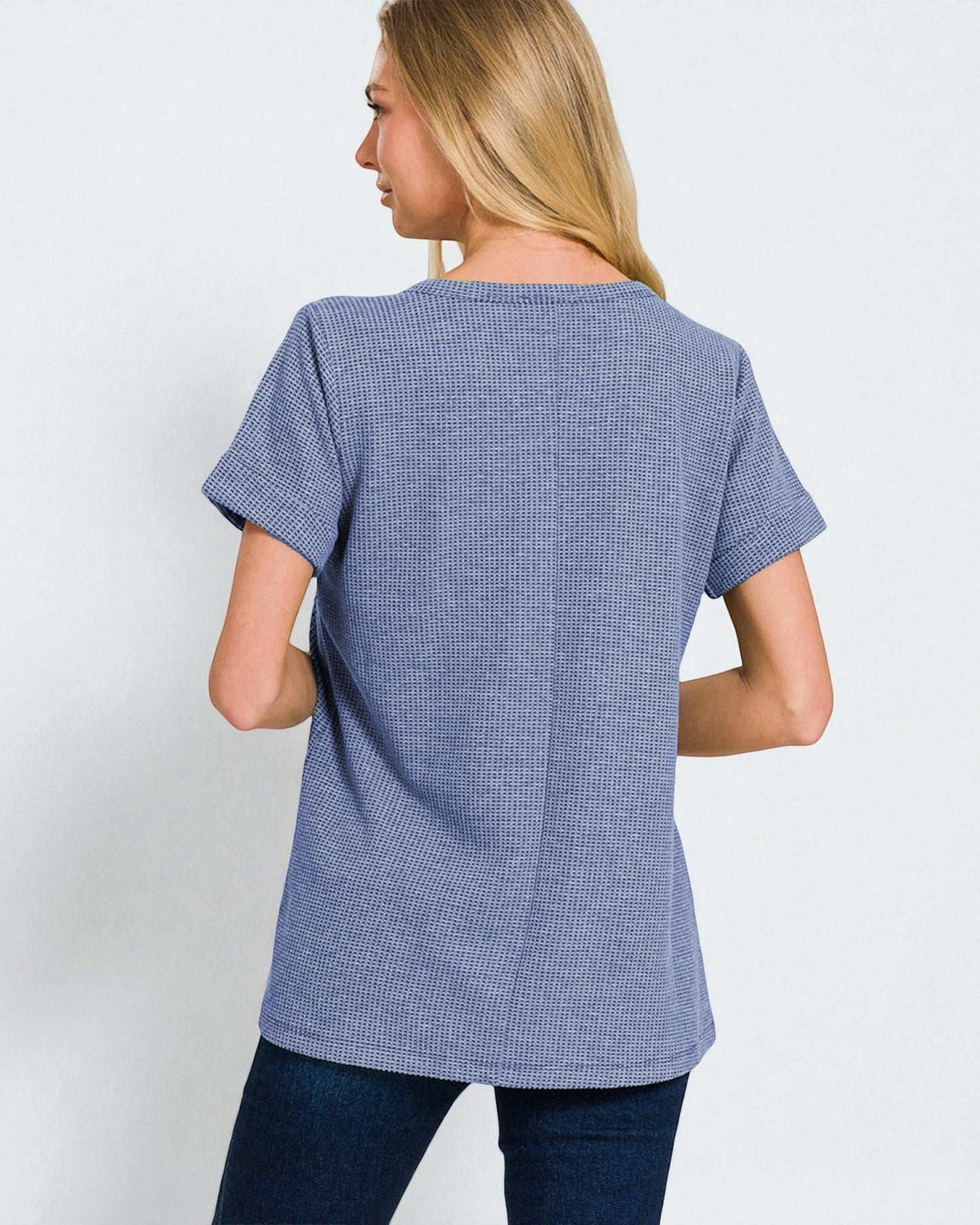 Woman wearing a blue checkered shirt against a white background