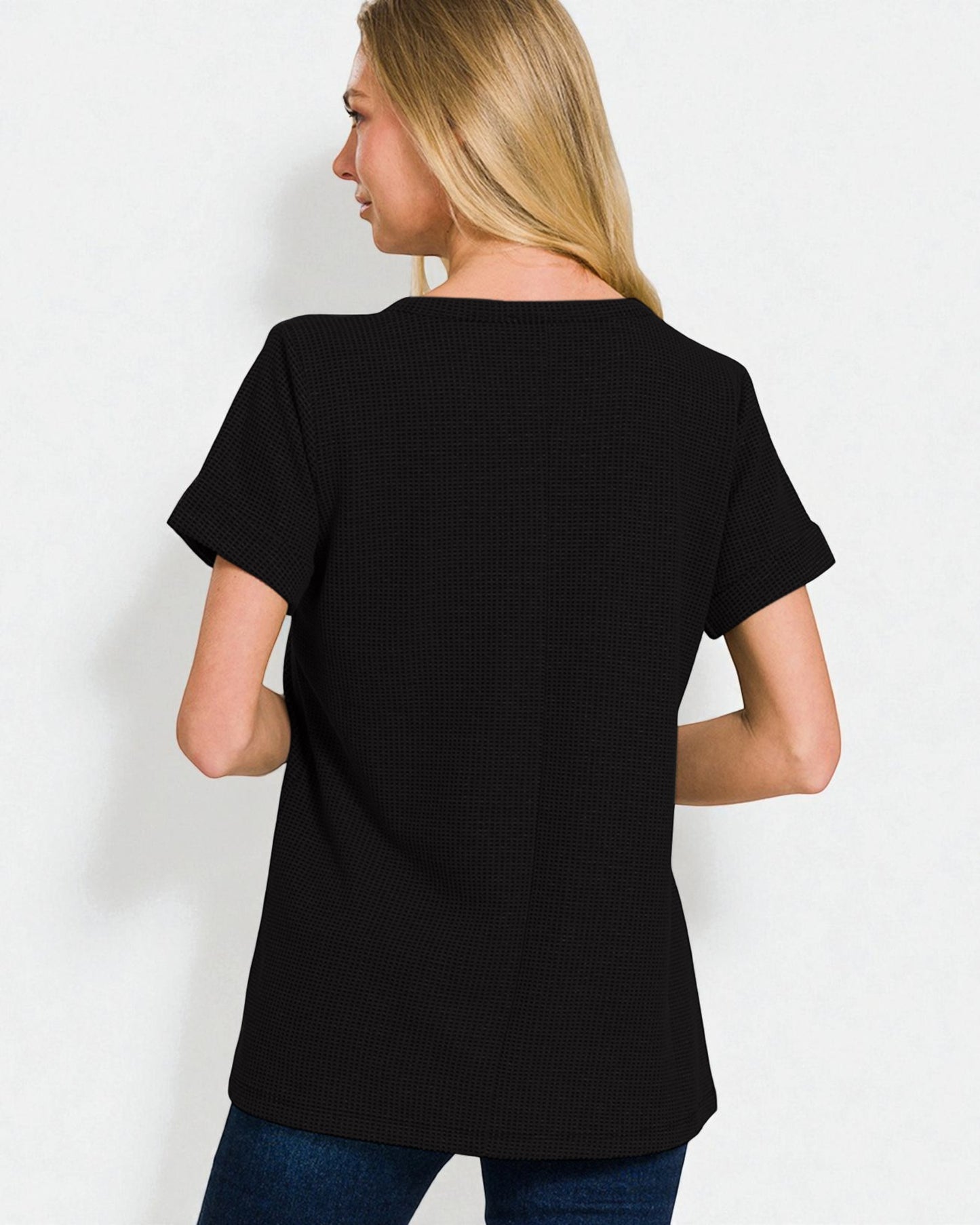 Person wearing a black t-shirt on a plain background