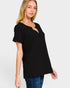 Woman wearing a black top with a plain background