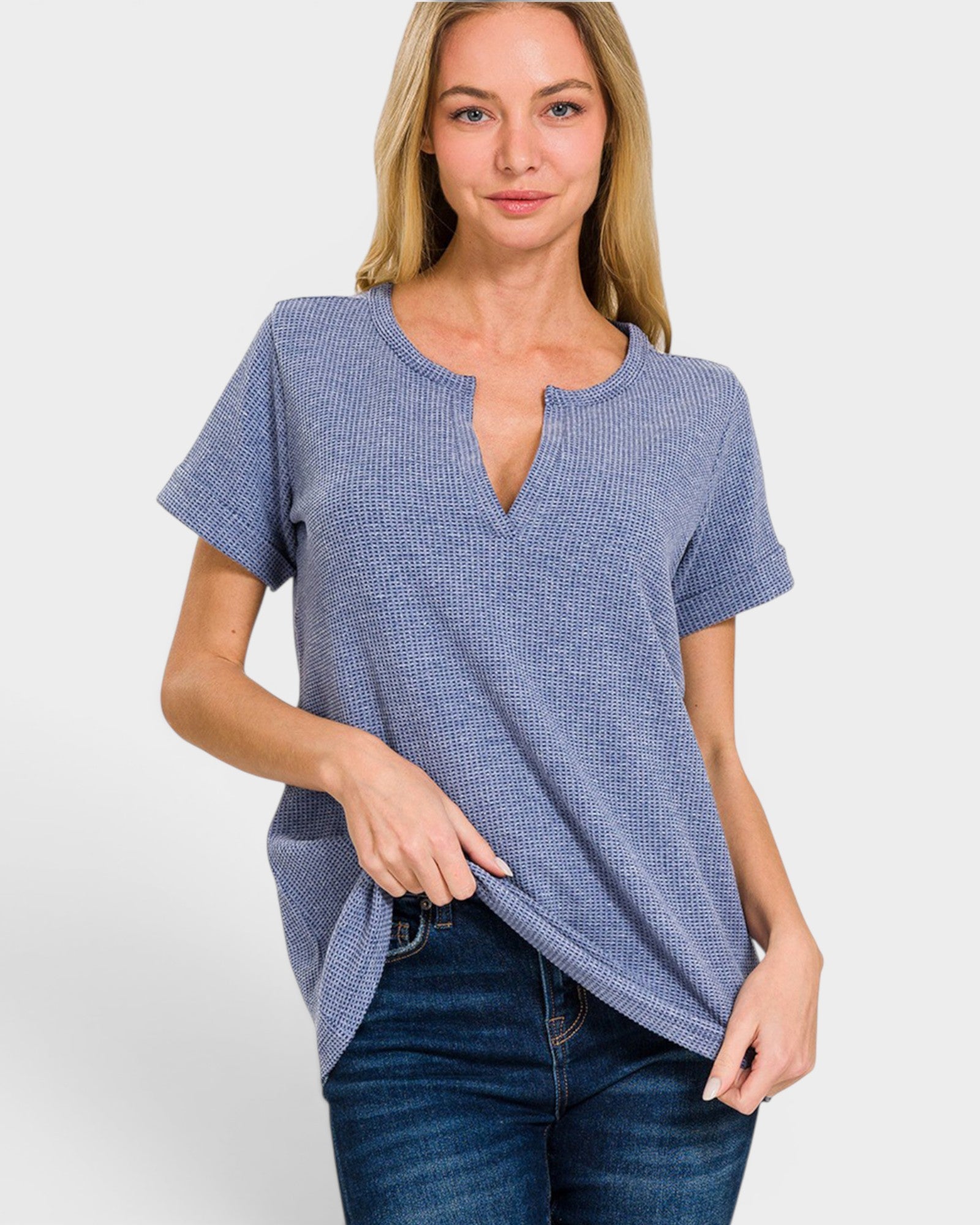 Woman wearing a blue checkered top and jeans on a white background
