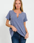 Woman wearing a blue textured top and jeans on a white background