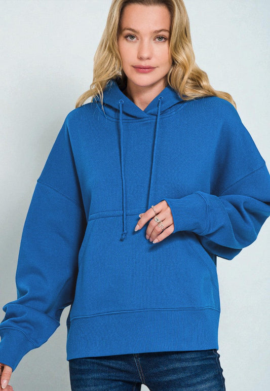 Person wearing a blue hoodie against a plain background