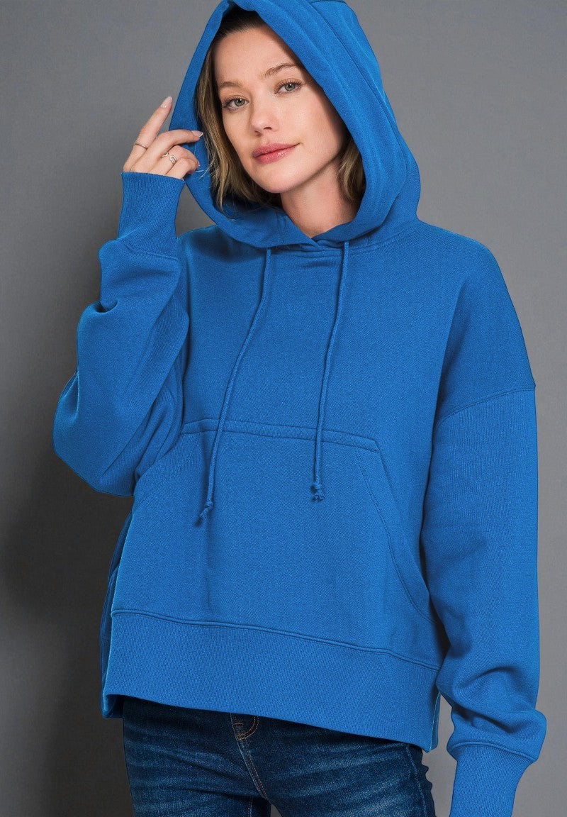 Person wearing a blue hoodie against a gray background