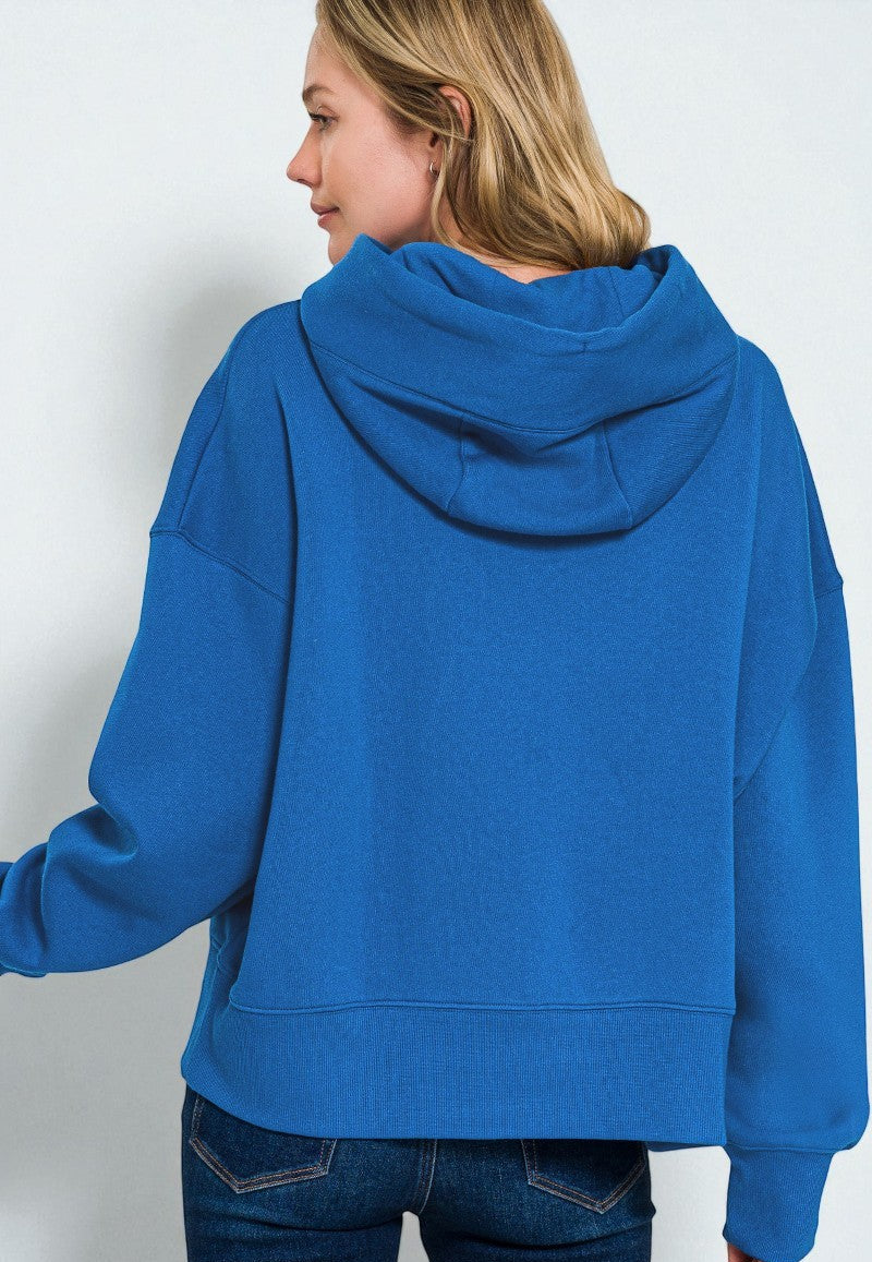 Person wearing a blue hoodie from behind on a plain background