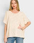 Woman wearing a beige oversized shirt and blue jeans on a light gray background