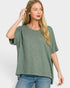 Woman wearing a green oversized t-shirt and blue jeans on a white background