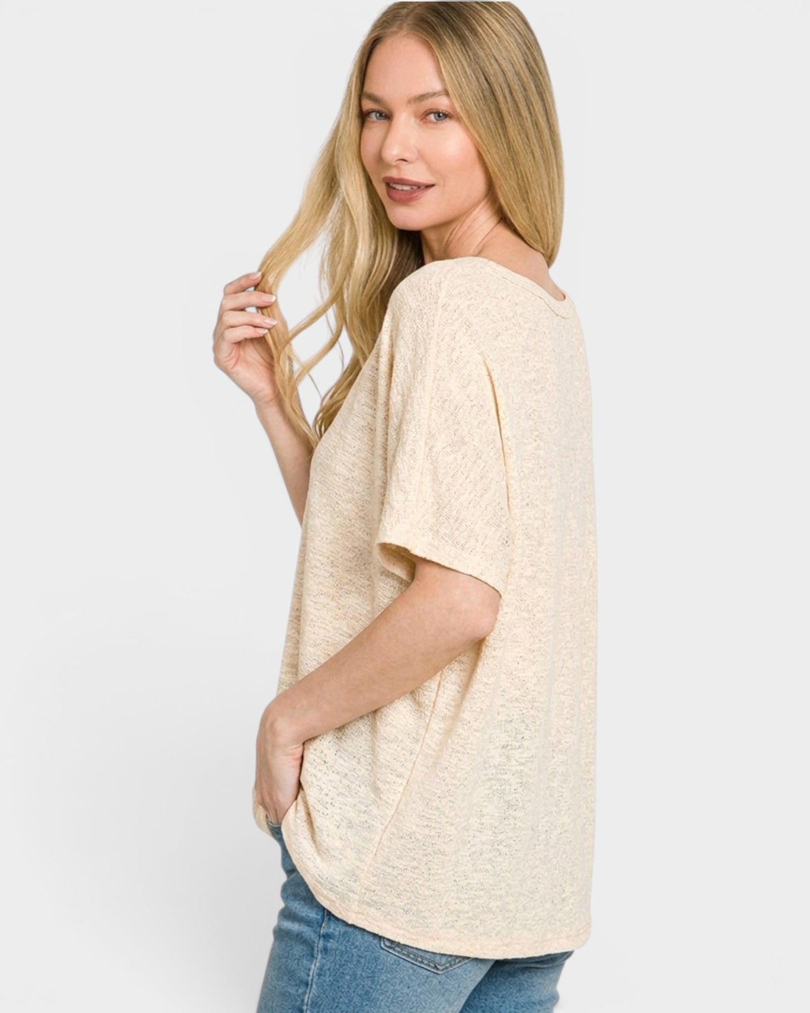 Woman wearing a beige oversized t-shirt on a white background