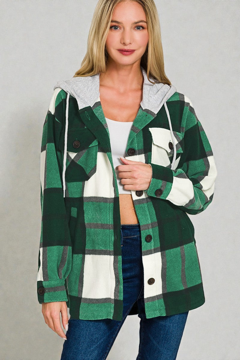 Woman wearing a green and white plaid jacket on a gray background