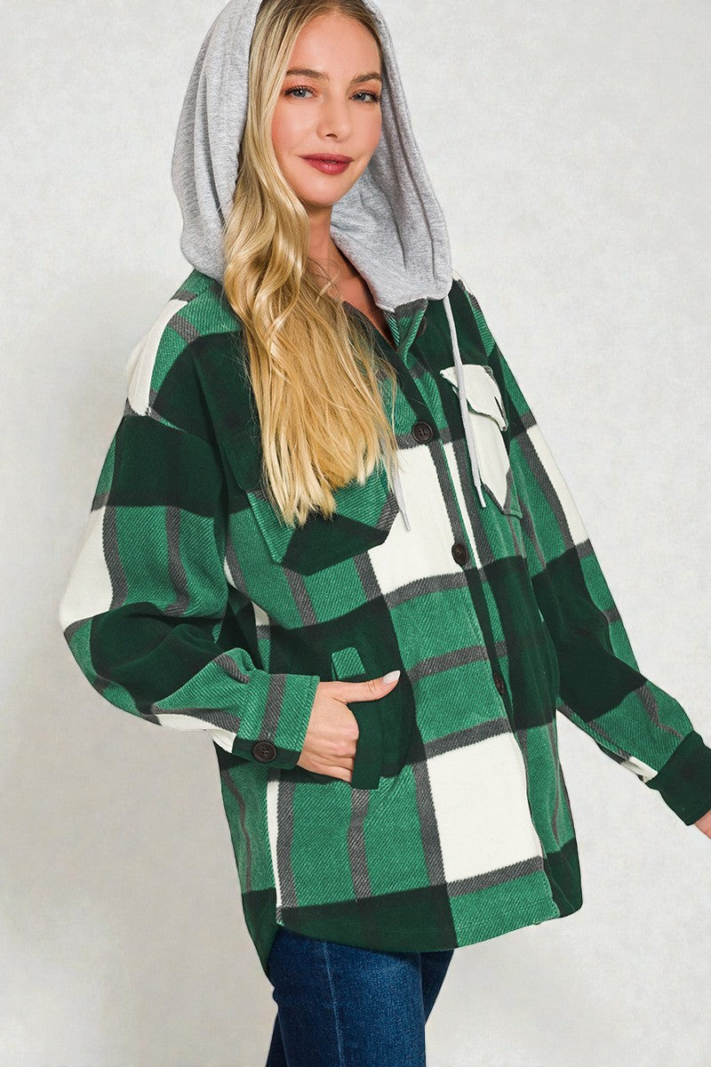 Person wearing a green and white plaid hoodie with a gray hood on a plain background