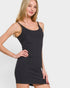 Woman wearing a black tank dress against a plain background