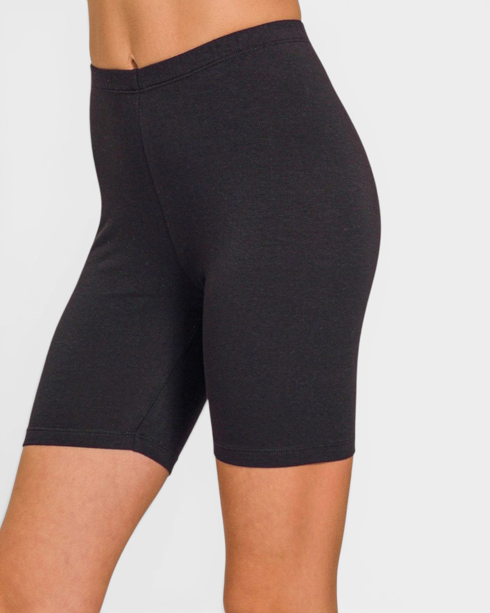 Black bike shorts worn by a person on a plain background