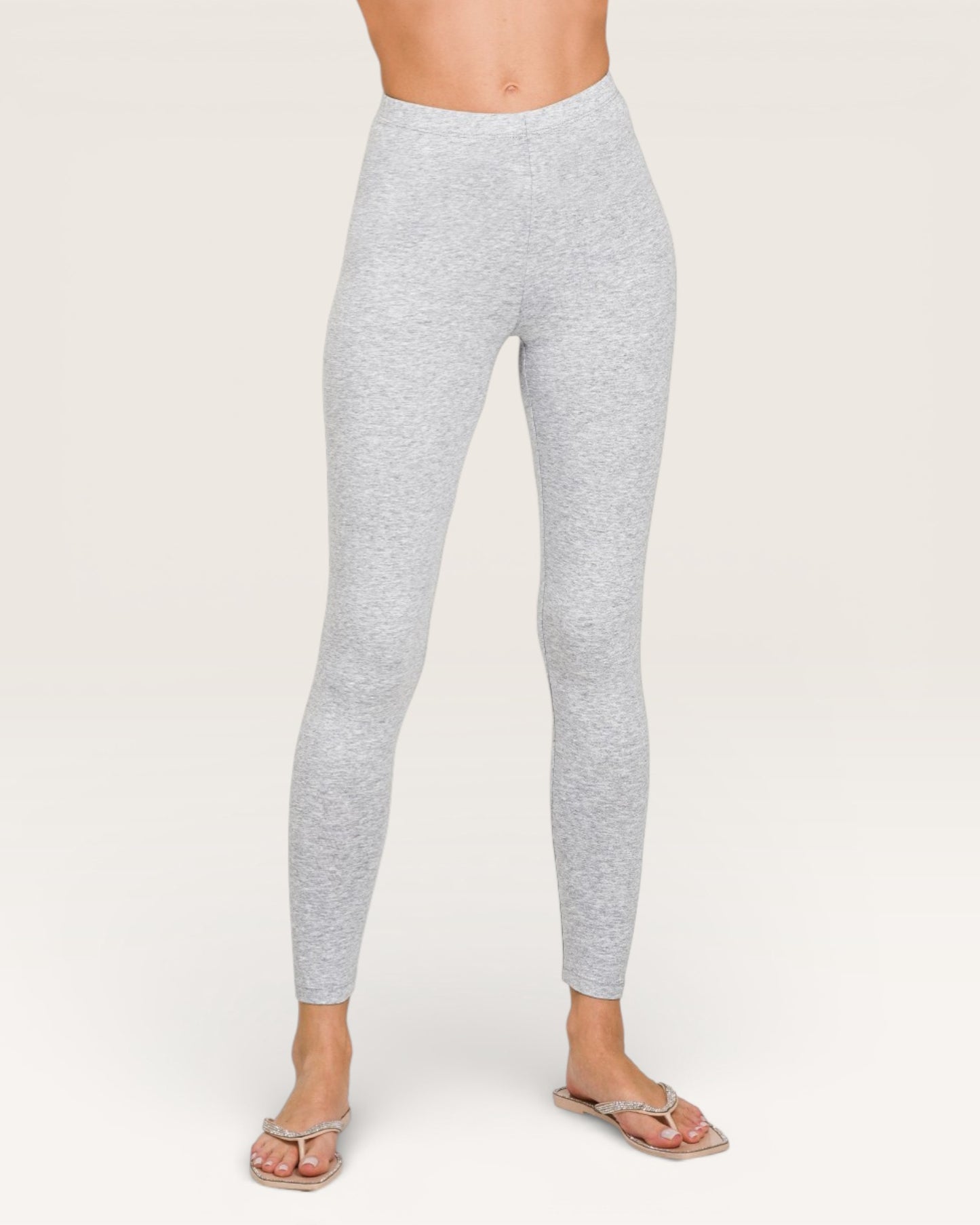 Gray leggings worn by a person on a white background