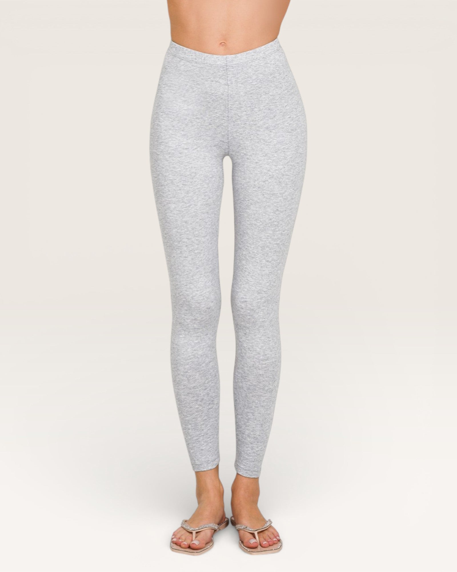 Gray leggings worn by a person on a white background