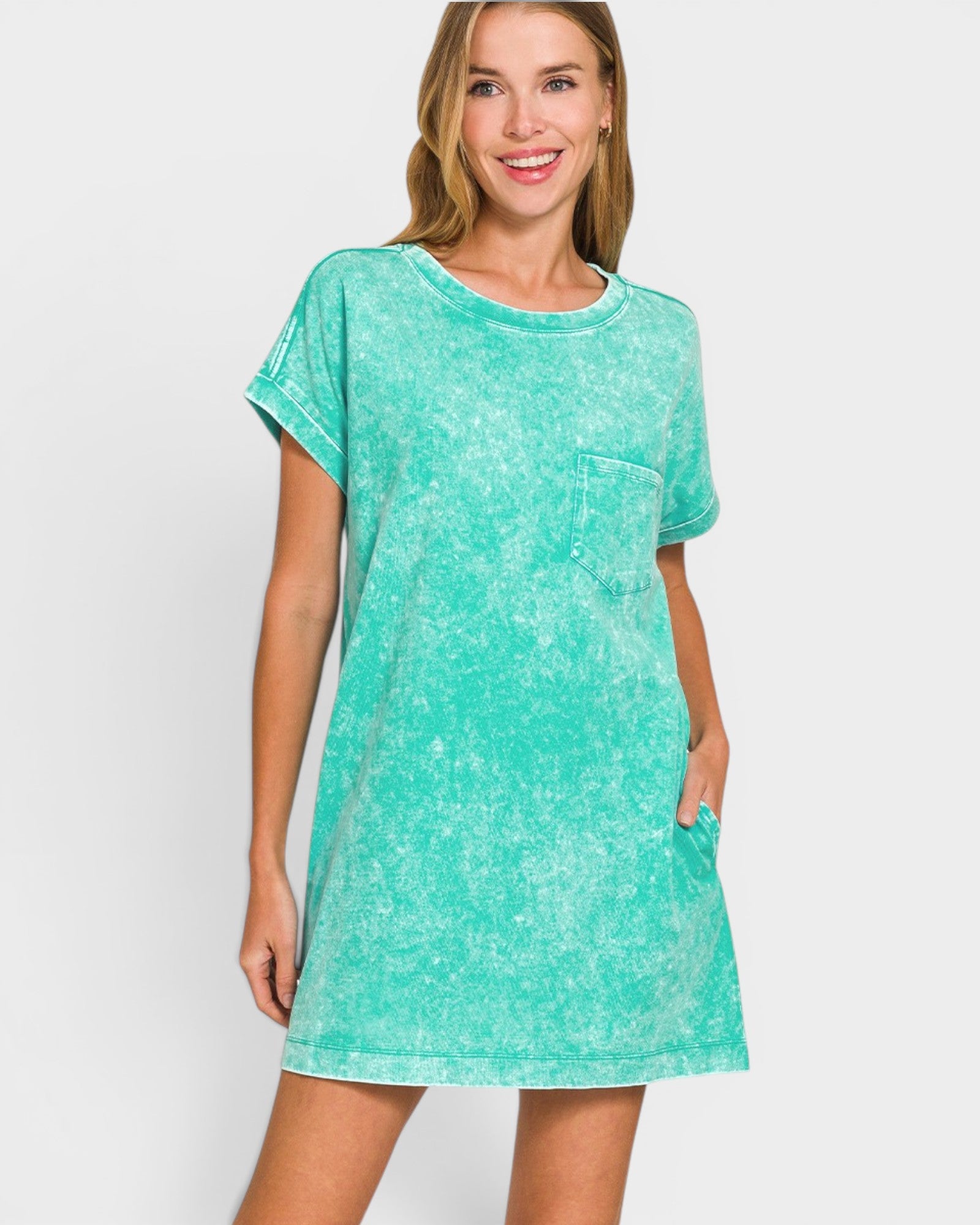 Woman wearing a teal t-shirt dress against a white background