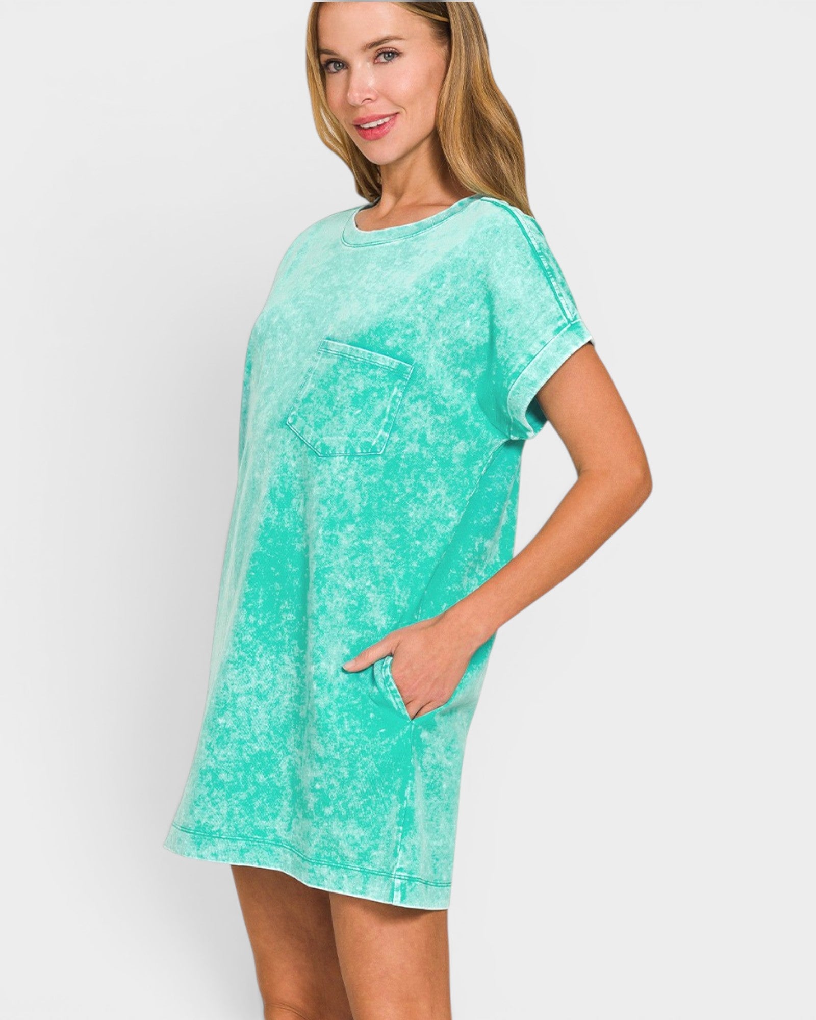Woman wearing a turquoise t-shirt dress on a white background