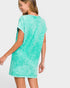 Woman wearing a turquoise t-shirt dress against a white background