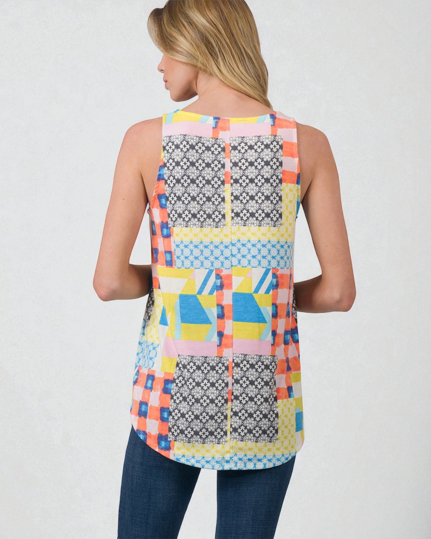 Woman wearing a colorful patterned sleeveless top on a plain background