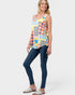 Woman wearing a colorful patterned top and dark jeans on a white background