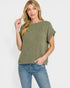 Woman wearing a green ribbed sweater and blue jeans on a white background