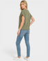 Woman wearing a green top and blue jeans on a white background