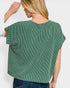Green knitted top worn by a person on a white background
