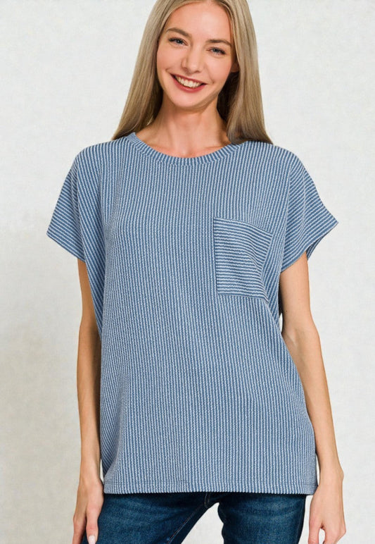 Woman wearing a blue striped tunic with a pocket on a plain background