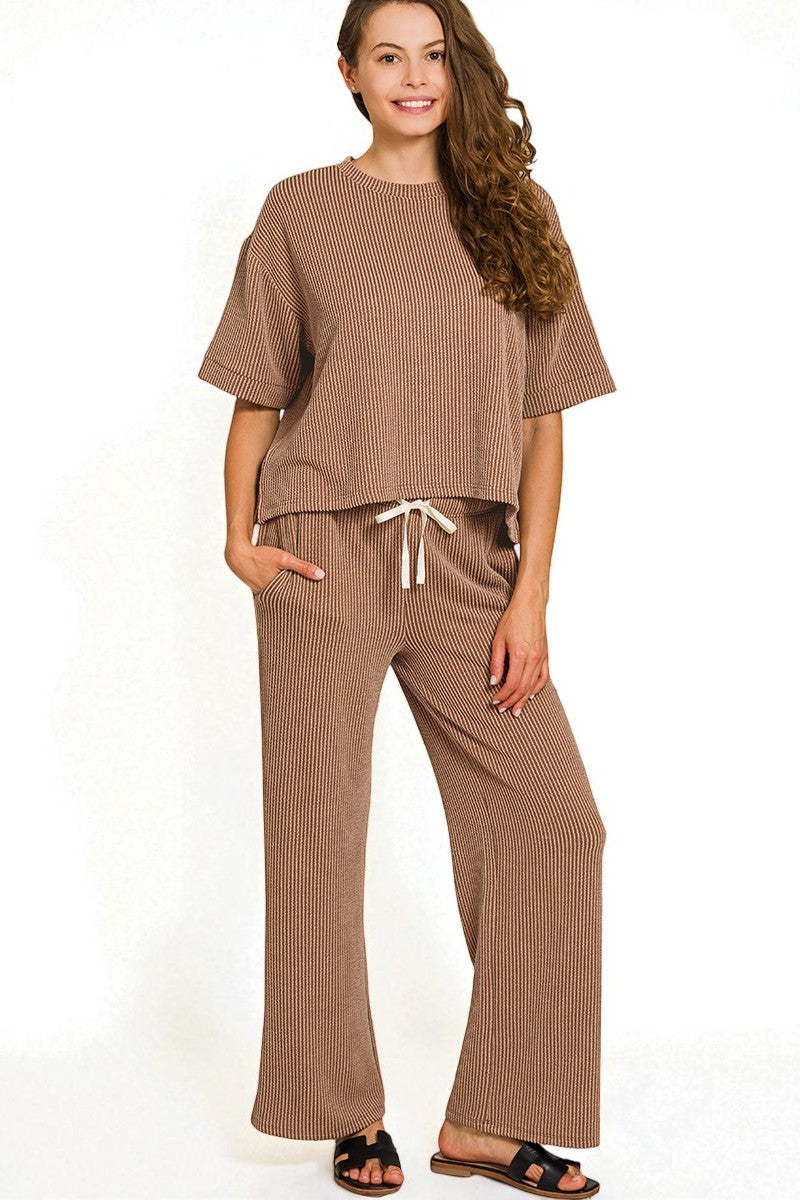 Woman wearing a brown ribbed outfit on a white background