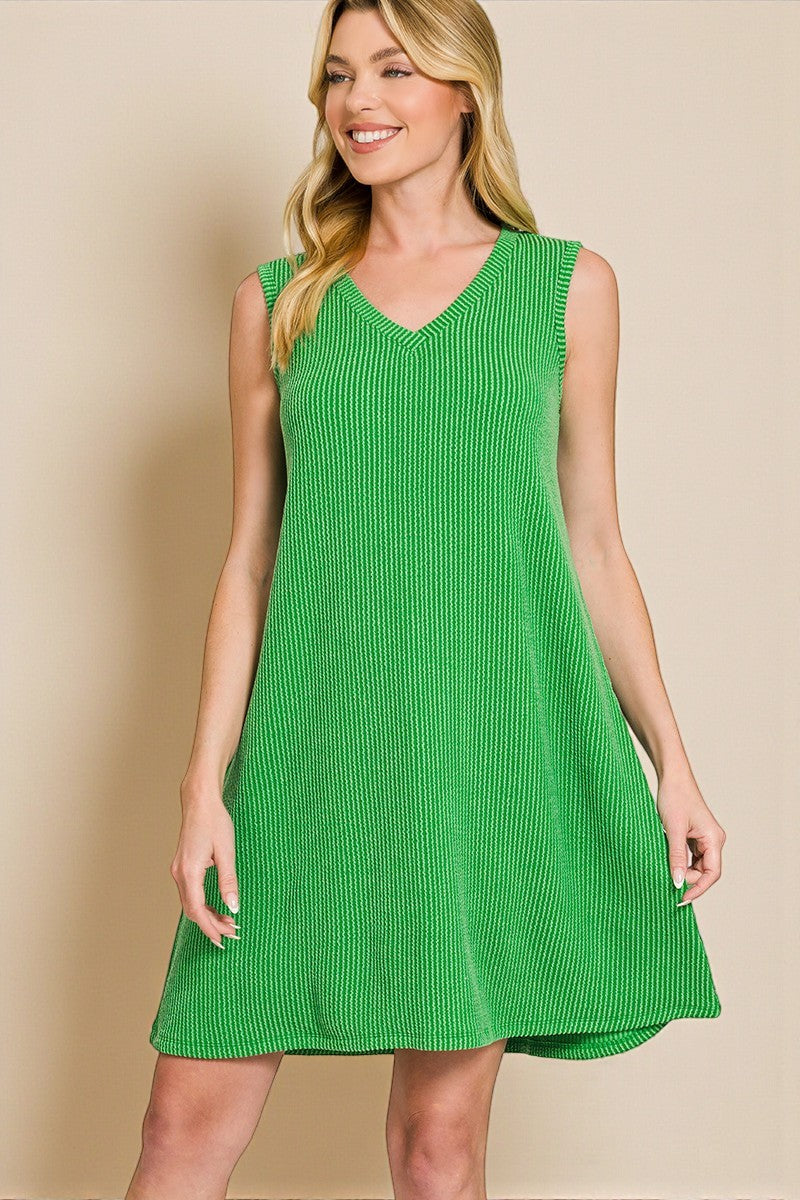 Woman wearing a green dress against a beige background