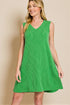Woman wearing a green dress against a beige background