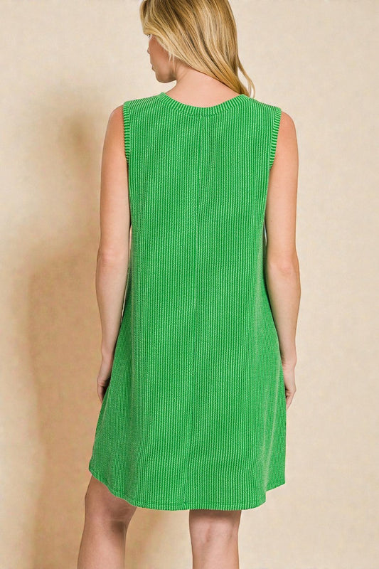 Green sleeveless dress on a beige background