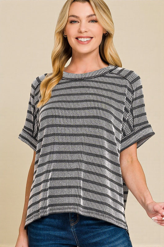 Woman wearing a black and white striped shirt against a beige background