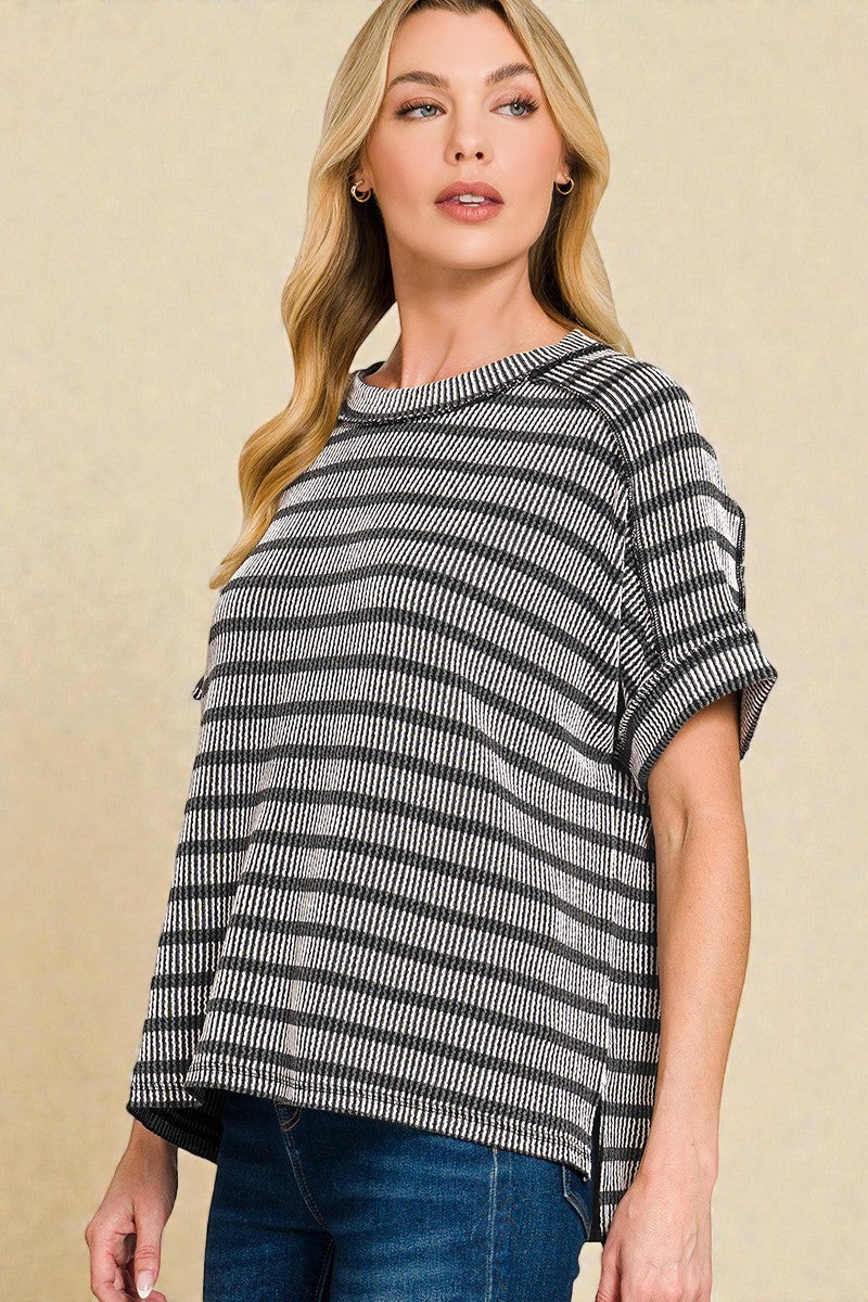 Woman wearing a black and white striped sweater against a beige background