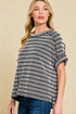 Woman wearing a black and white striped sweater against a beige background