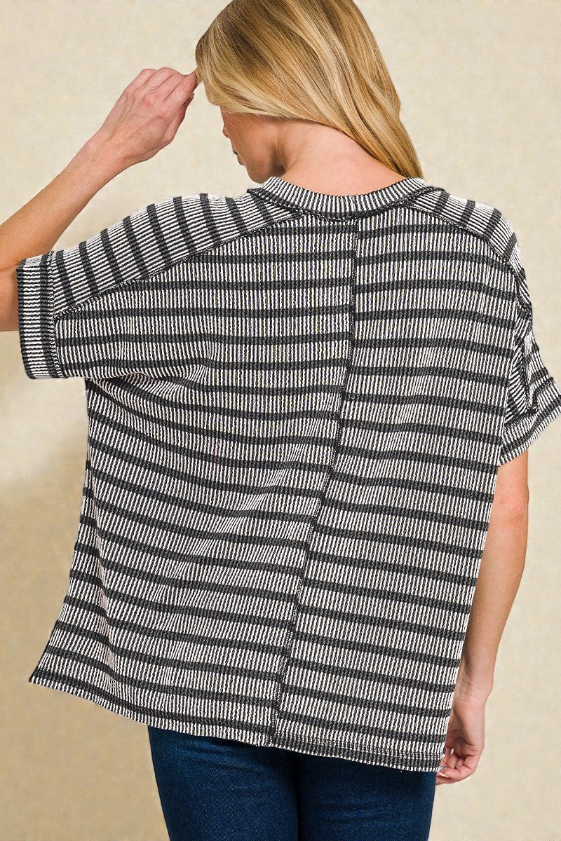 Woman wearing a black and white striped shirt against a beige background